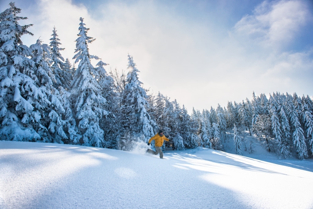 Mann läuft durch hohen Schnee im Schwarzwald