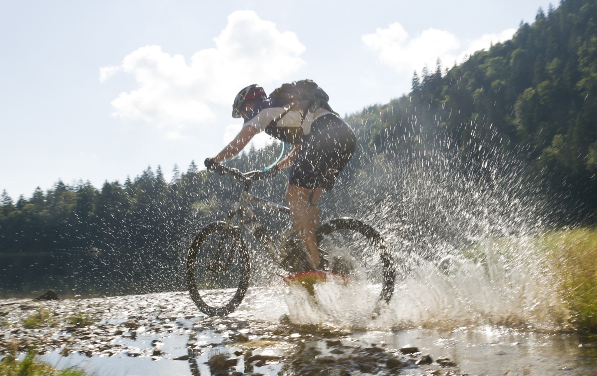 Mountainbiker im Schwarzwald fährt durch Wasser